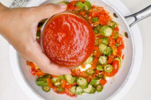 Adding tomato sauce.
