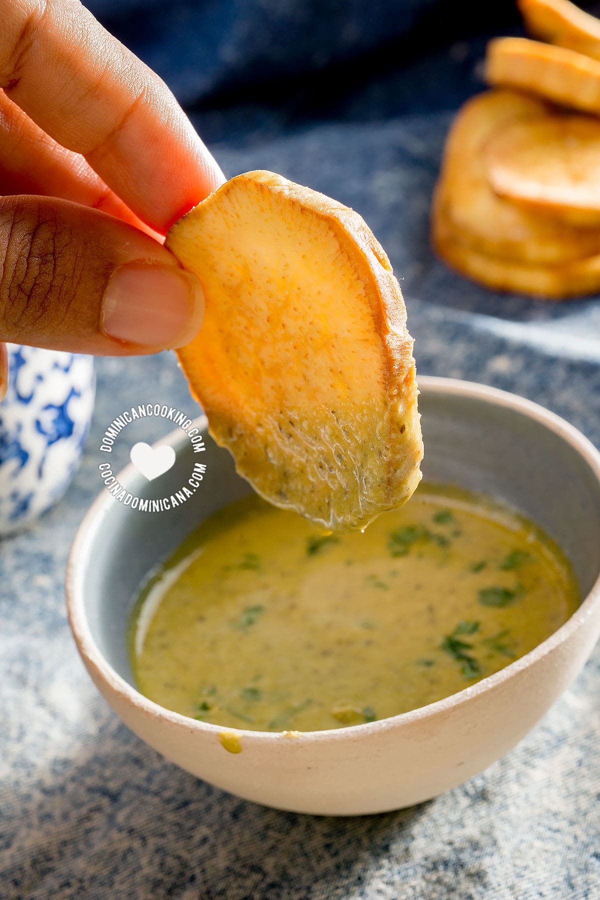 Hand holding a batata fry in dip.