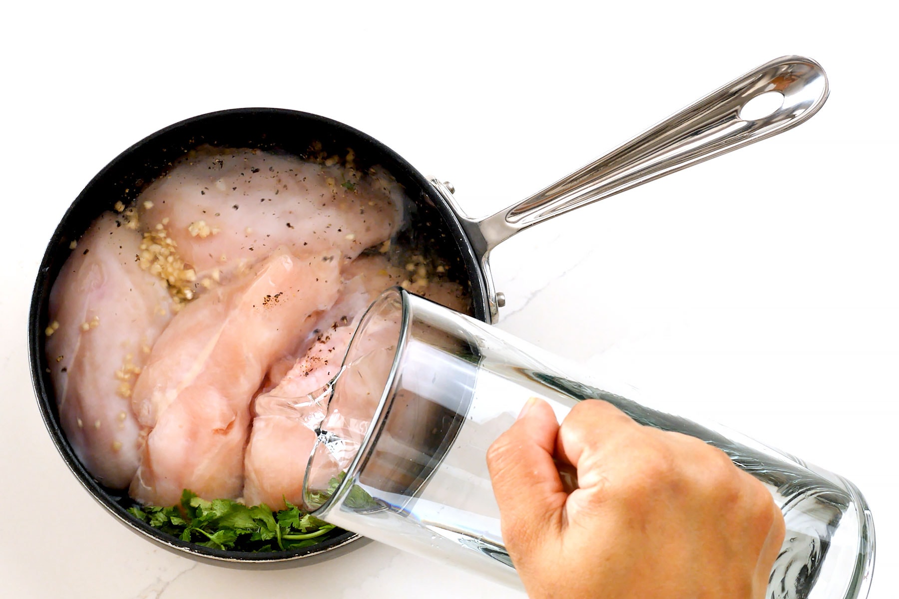 Adding water to chicken in a pot