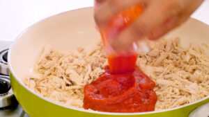 Adding tomato sauce to chicken