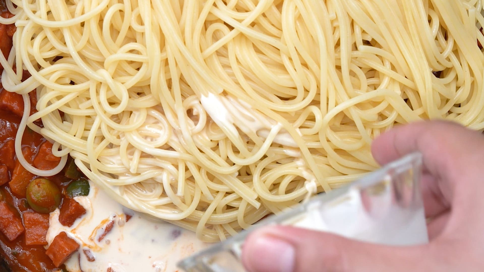 Adding milk to spaghetti in tomato sauce