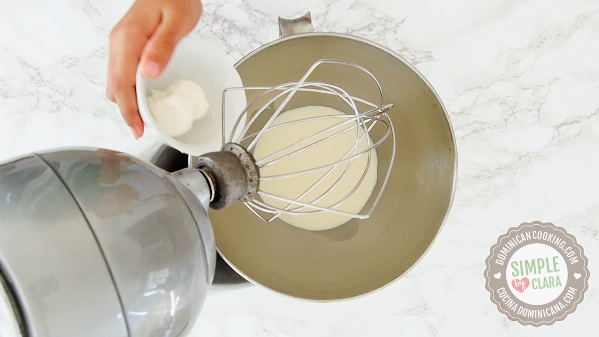 Adding cream cheese to mixing bowl with cream