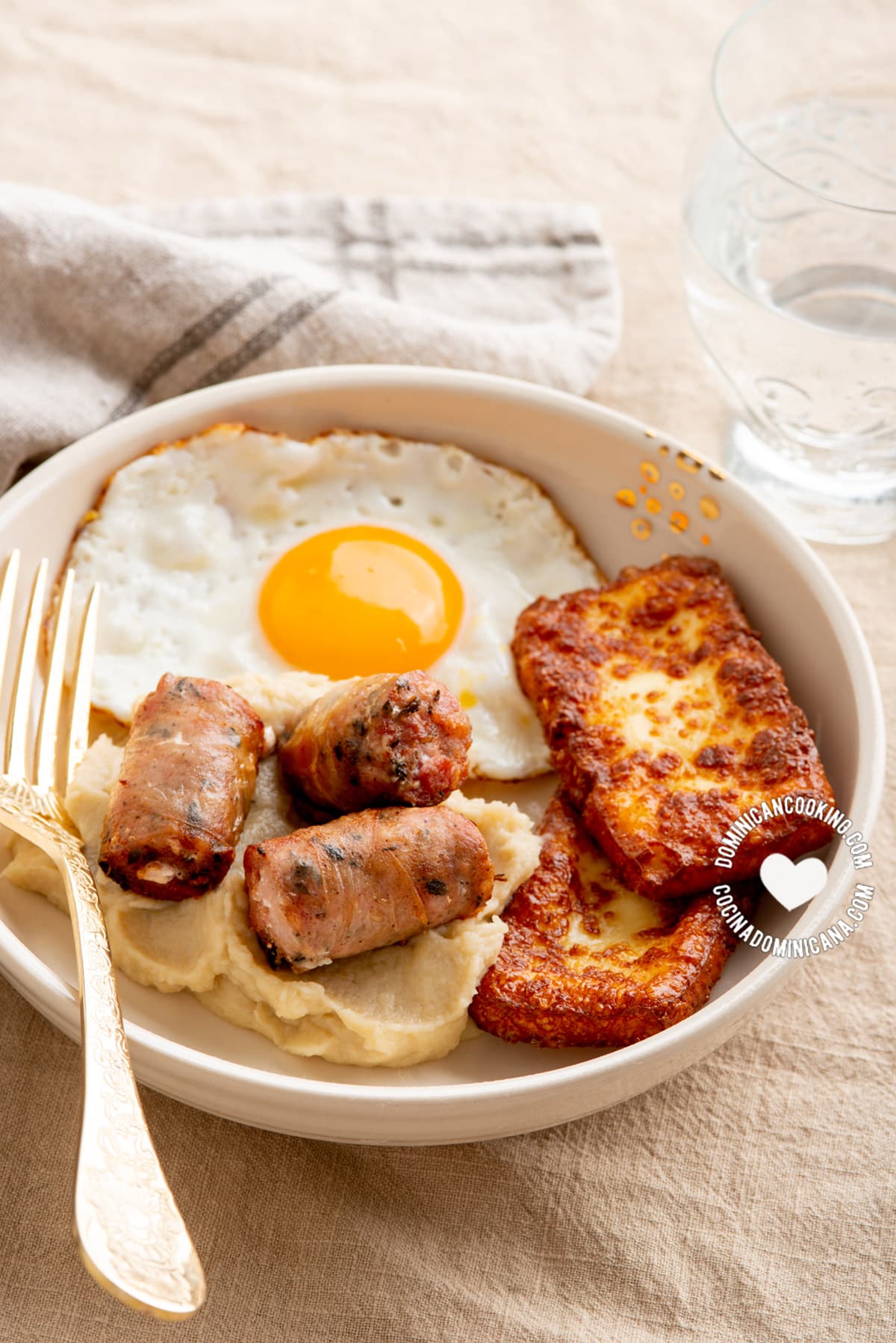 Dominican keto breakfast of fried cheese, egg and sausage with mash