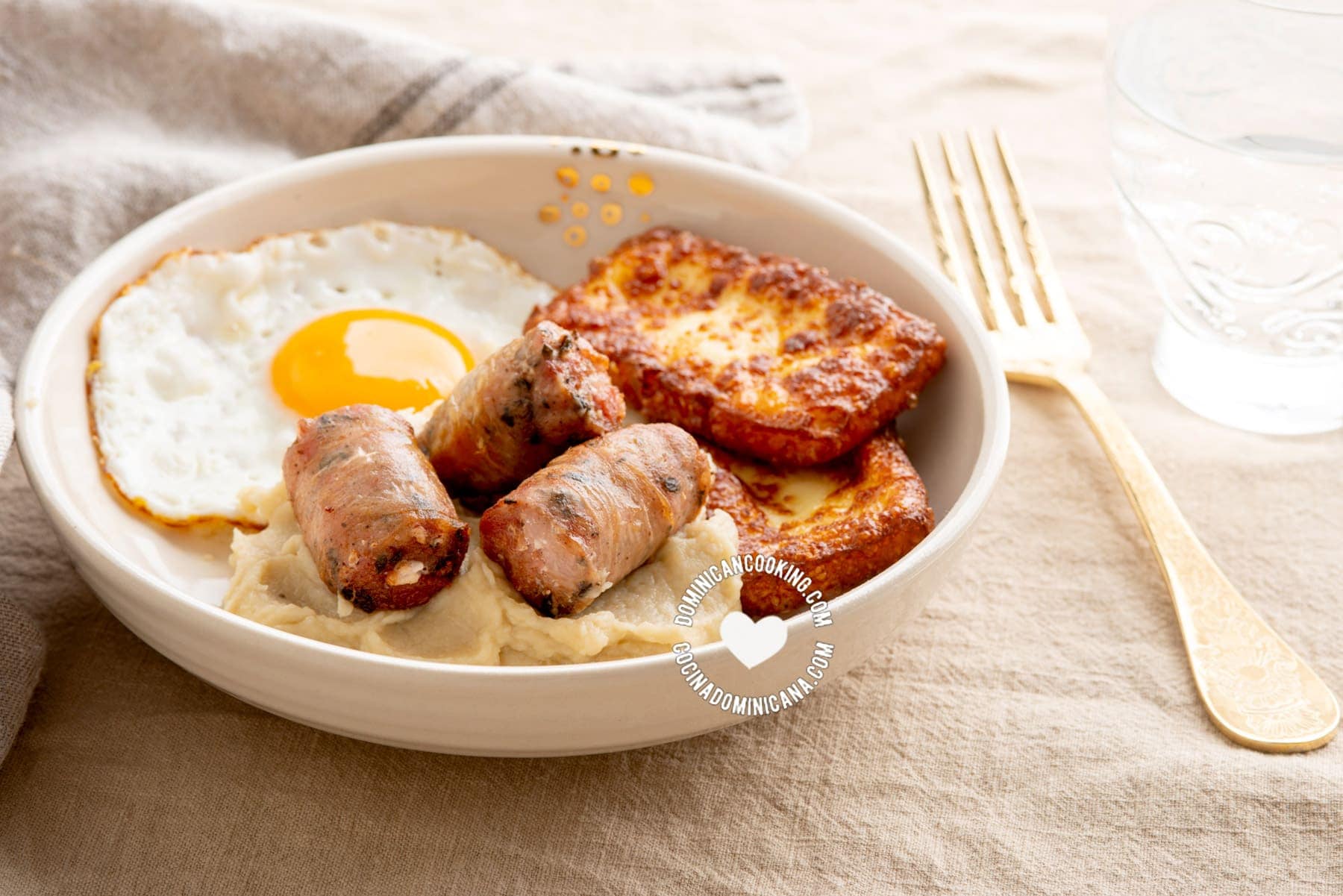 Dominican keto breakfast of fried cheese, egg and sausage with mash