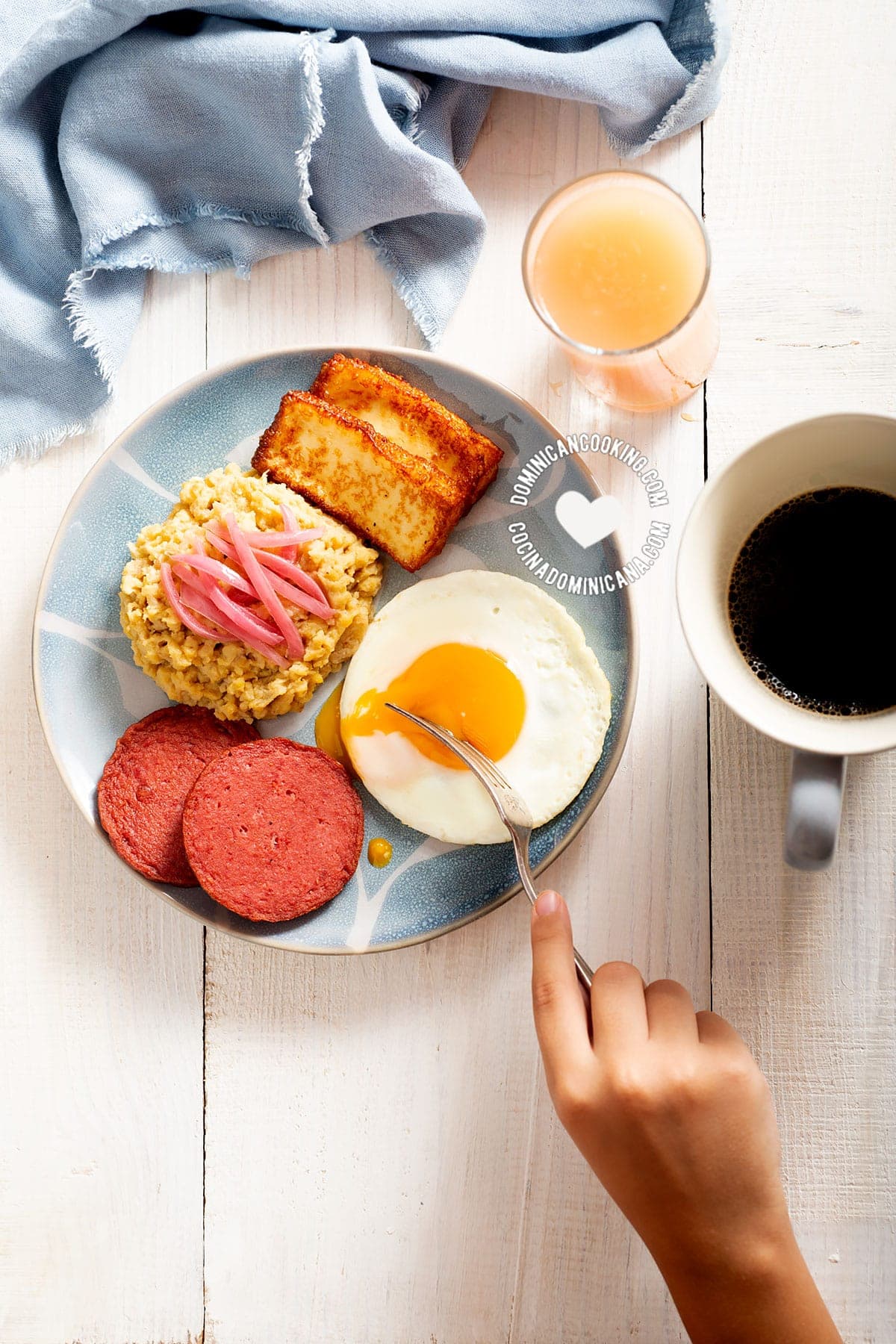 Plate of mangú with cheese, salami, and eggs.