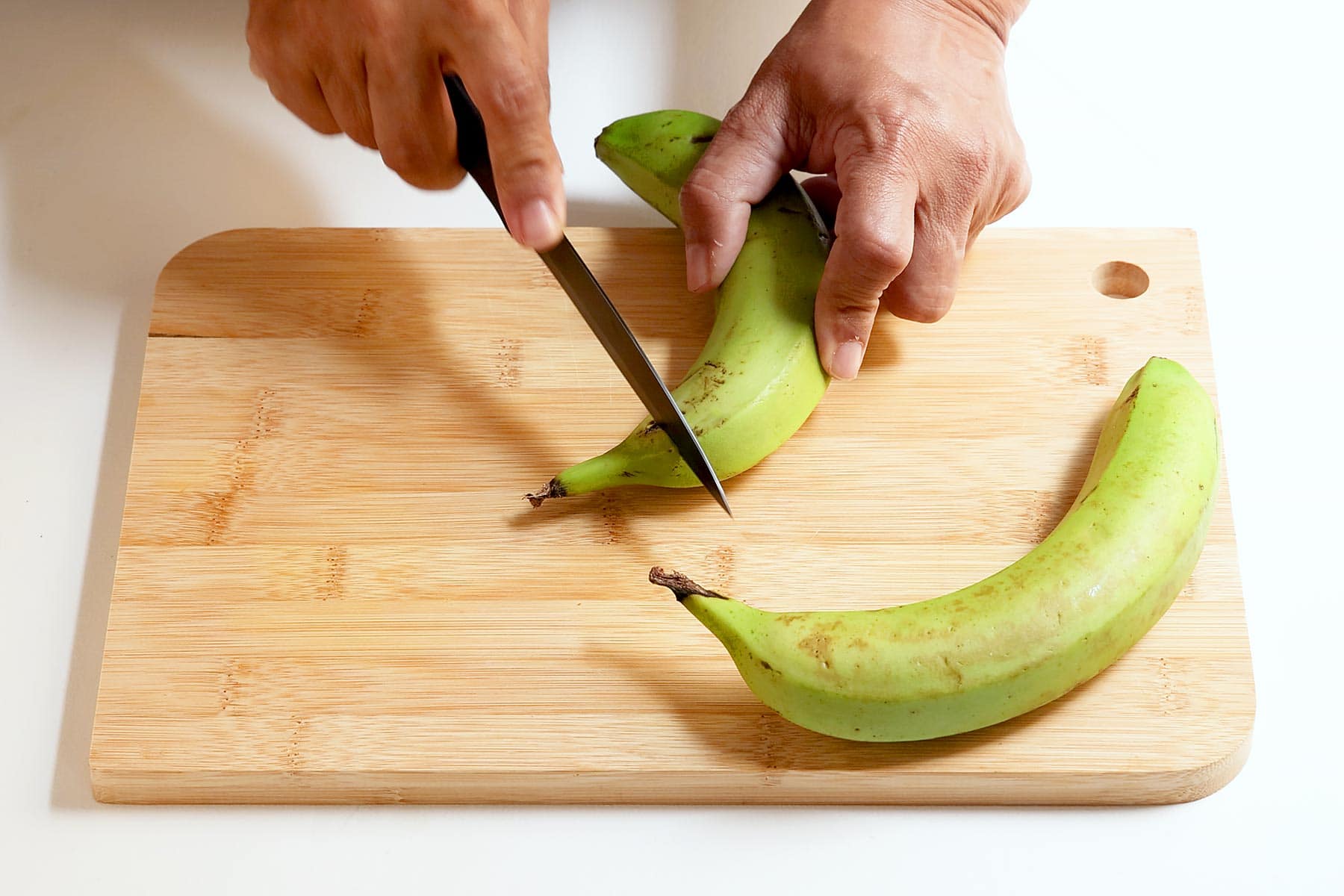 Peeling guineos.