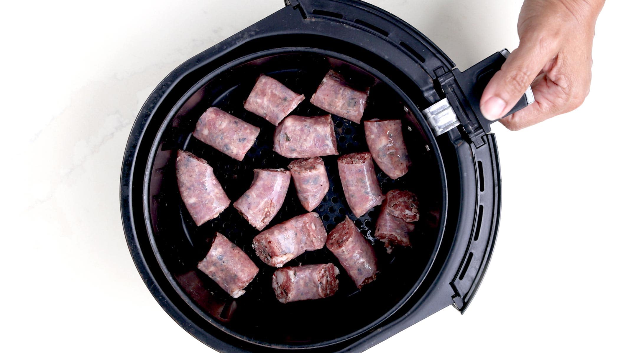 Longaniza in air fryer basket.