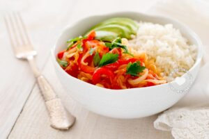 Cabbage stew served with rice and avocado