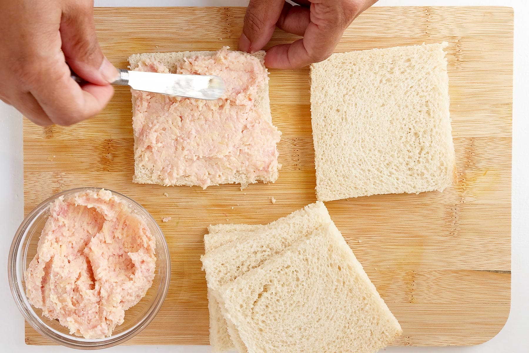 Spreading mezcla on bread.